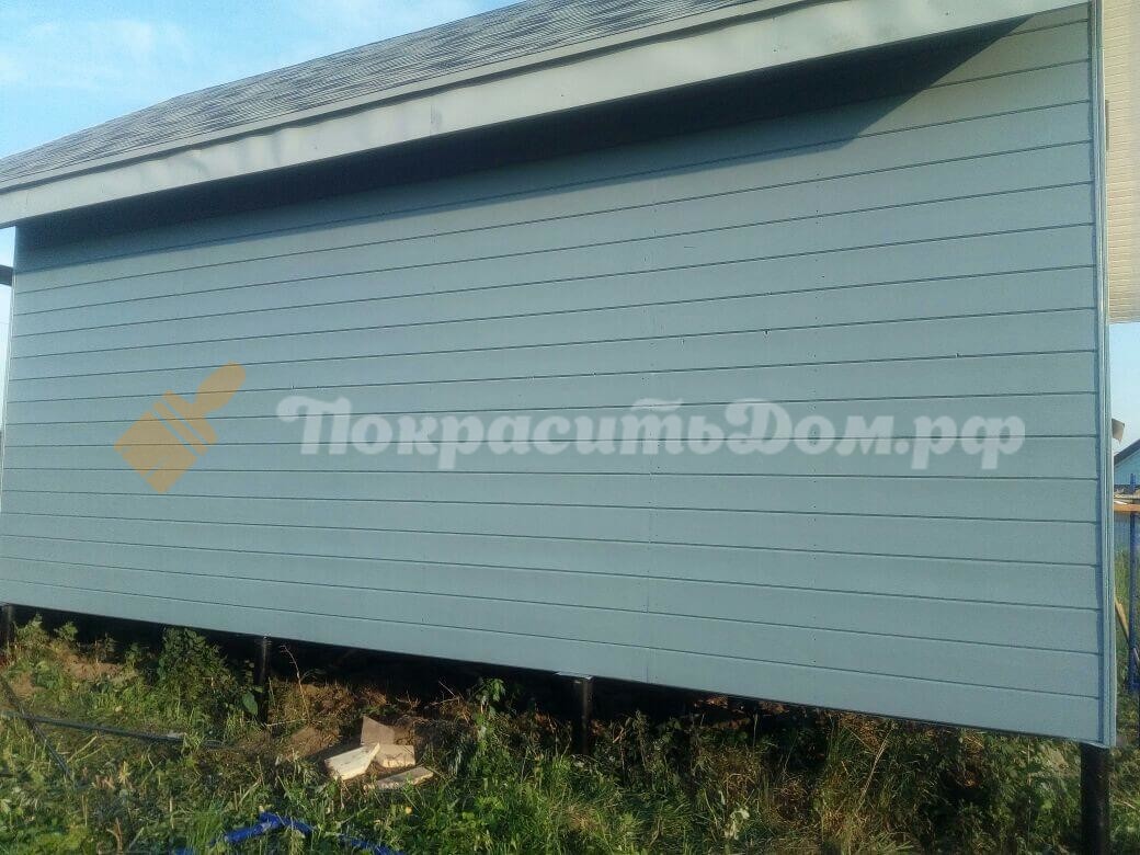 одна из стен каркасного дома покрашенная в синий цвет
